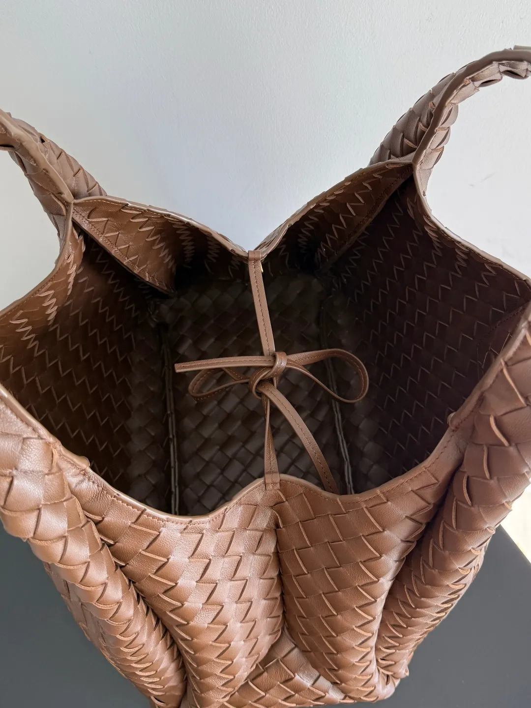 Batch 2760 new products are coming! BOTTEGA VENETA Bottega Veneta's 2025 new Campana shoulder bag is on the market~ First of all, I would like to praise the weight of this bag. As a not too small bag, it is very light for daily use. For people like me who need to carry a lot of belongings when going out, this advantage is great, and it greatly reduces the burden of traveling. 🛍️The shape is a bit like a combination of parachute and jodie. The blunt triangle shape is cute and honest. Carrying it on your back when going shopping is a good mood accelerator. The handles and body of the bag are both classic weaves. A tie is added to the original open design. If it is not tied up, the bag will look like a small vegetable basket when carried. Style number: 844250 Size: 39*24*18.5cm